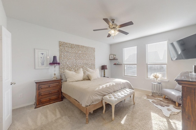 bedroom featuring light colored carpet, baseboards, and ceiling fan