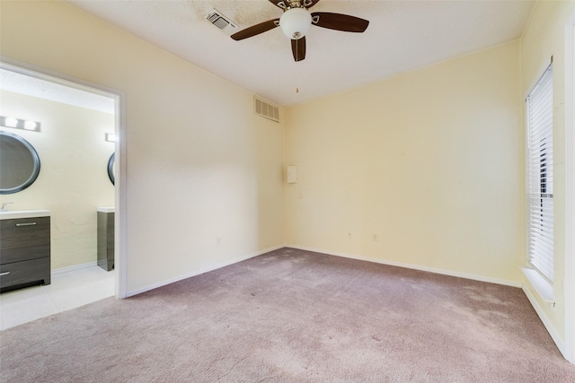 unfurnished bedroom with baseboards, visible vents, and light carpet