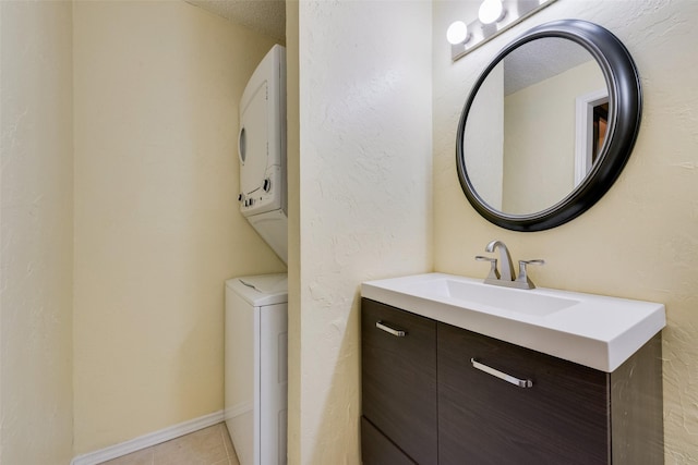 bathroom featuring vanity, baseboards, a textured ceiling, tile patterned floors, and a textured wall