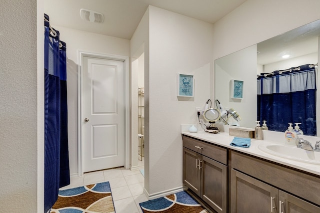 full bathroom featuring vanity, a shower with curtain, baseboards, visible vents, and tile patterned floors