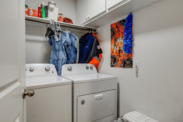 clothes washing area featuring cabinet space and washing machine and dryer