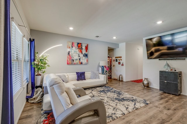 living area with visible vents, recessed lighting, and wood finished floors