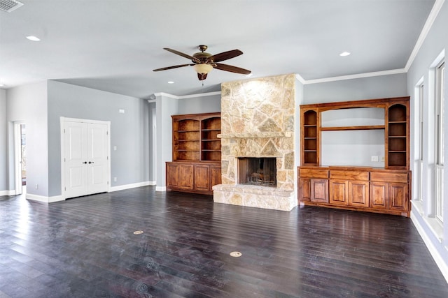 unfurnished living room featuring crown molding, baseboards, dark wood finished floors, a wealth of natural light, and a fireplace