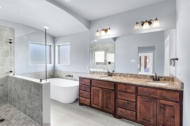 full bath with a sink, a soaking tub, double vanity, and a tile shower