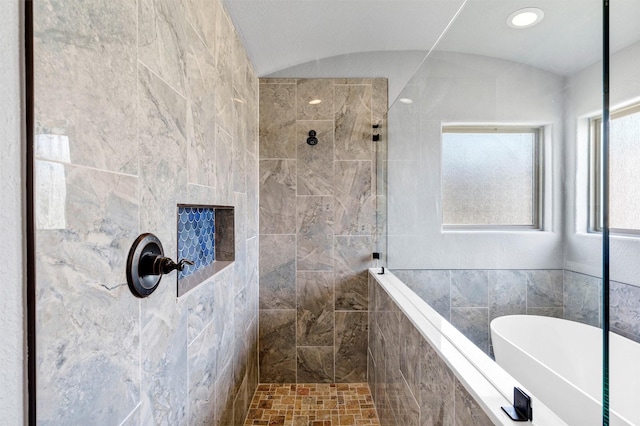 full bathroom featuring a soaking tub, vaulted ceiling, and walk in shower