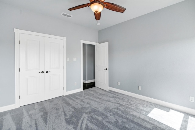 unfurnished bedroom featuring baseboards, visible vents, ceiling fan, a closet, and carpet flooring