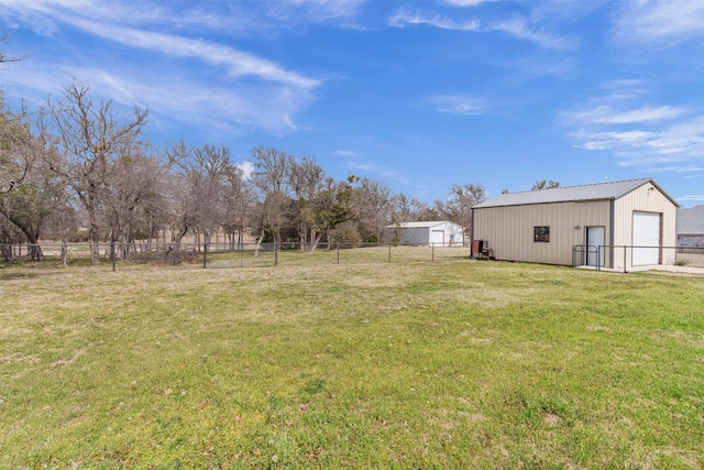 view of yard with a detached garage, an outbuilding, a pole building, and fence