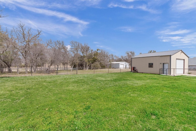 view of yard with a garage, an outbuilding, a pole building, and fence