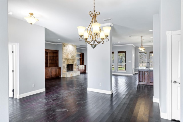 interior space featuring visible vents, dark wood-type flooring, a stone fireplace, and crown molding