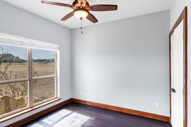 spare room with hardwood / wood-style floors, plenty of natural light, a ceiling fan, and baseboards