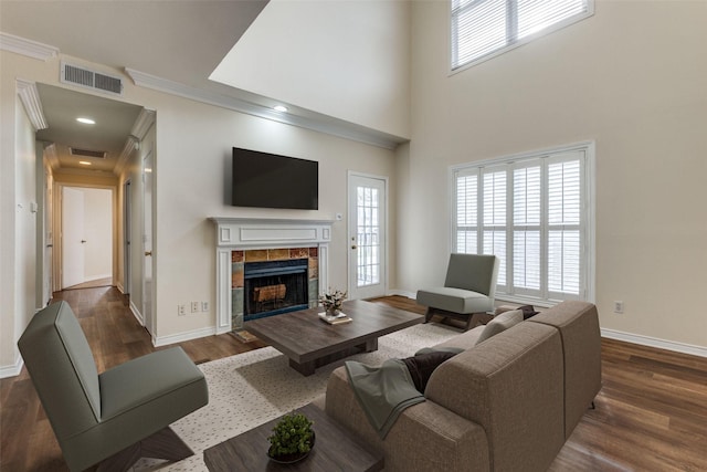 4034 Rawlins St Unit 102, Dallas, TX 75219 - living room featuring healthy amount of natural light, a tile fireplace, dark wood-style floors, baseboards, and ornamental molding