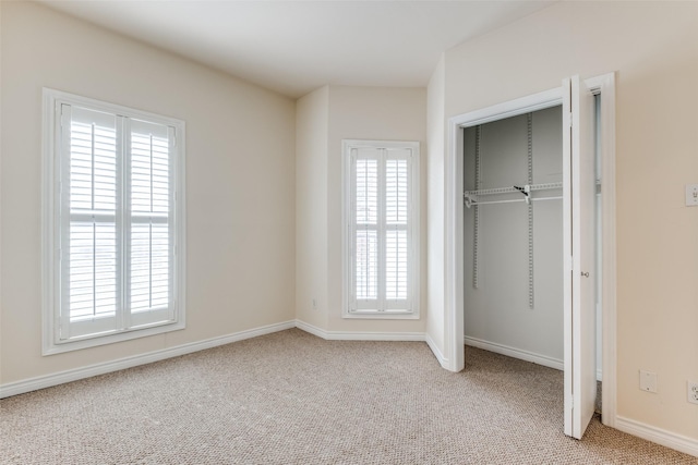 4034 Rawlins St Unit 102, Dallas, TX 75219 - unfurnished bedroom with multiple windows, light colored carpet, baseboards, and a closet
