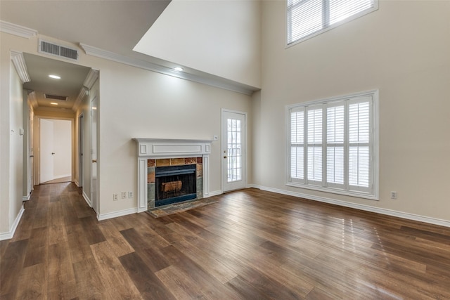 4034 Rawlins St Unit 102, Dallas, TX 75219 - unfurnished living room with a tile fireplace, baseboards, wood finished floors, and ornamental molding