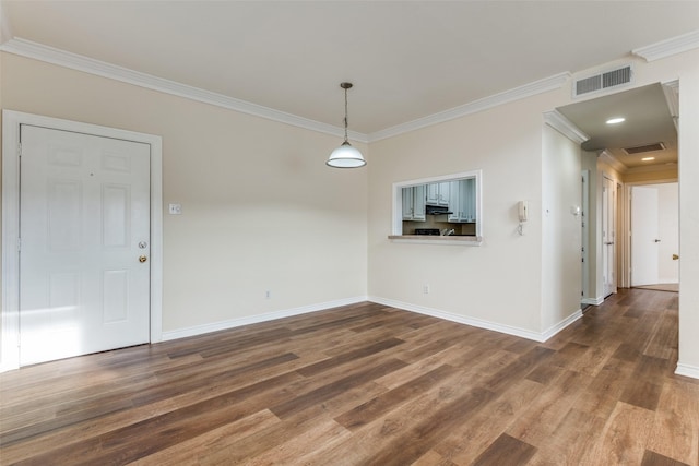 spare room with visible vents, crown molding, baseboards, and wood finished floors