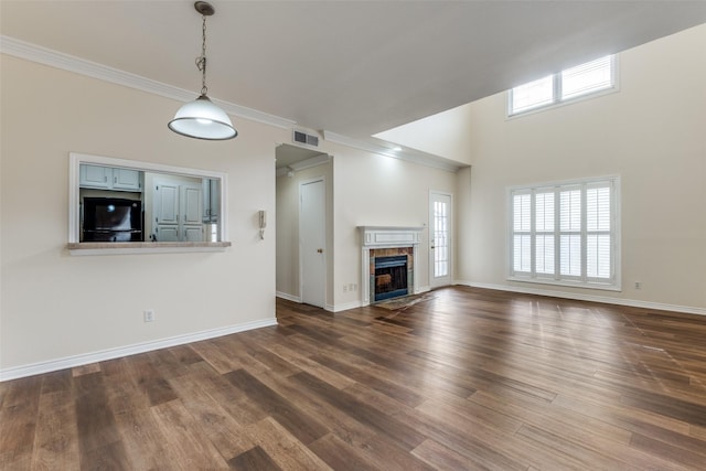 4034 Rawlins St Unit 102, Dallas, TX 75219 - unfurnished living room with a tile fireplace, dark wood-style floors, baseboards, and crown molding