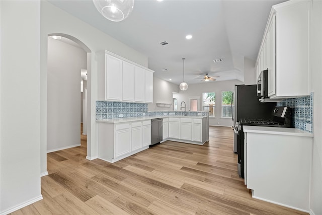 kitchen with visible vents, a peninsula, white cabinets, appliances with stainless steel finishes, and light countertops