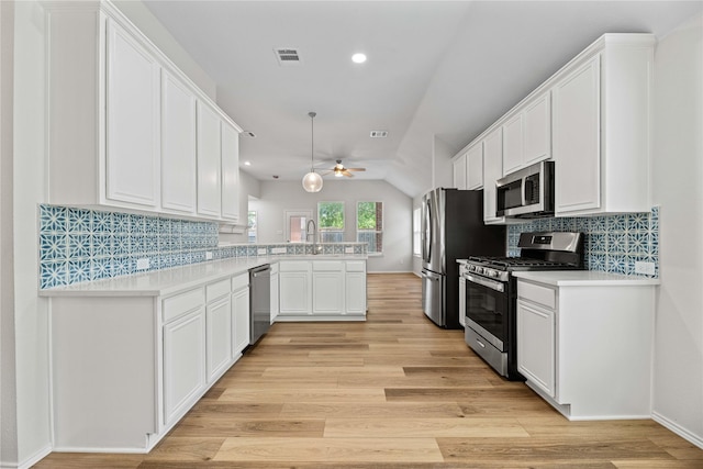 kitchen with visible vents, a peninsula, stainless steel appliances, and light wood-type flooring