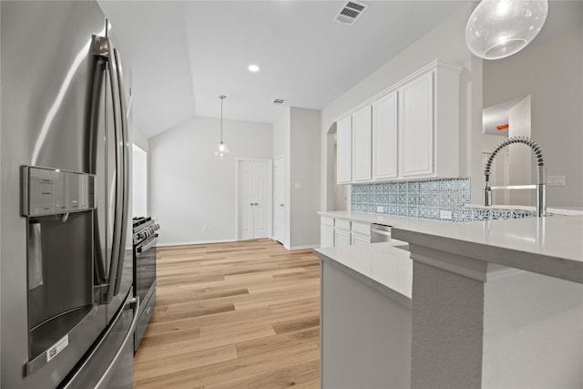 kitchen with light wood finished floors, visible vents, decorative backsplash, white cabinets, and stainless steel appliances