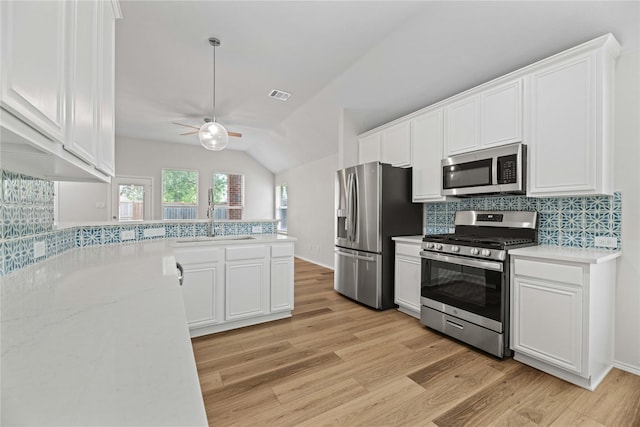 kitchen with visible vents, white cabinets, stainless steel appliances, and a sink