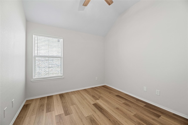 spare room featuring light wood-style flooring, lofted ceiling, baseboards, and ceiling fan