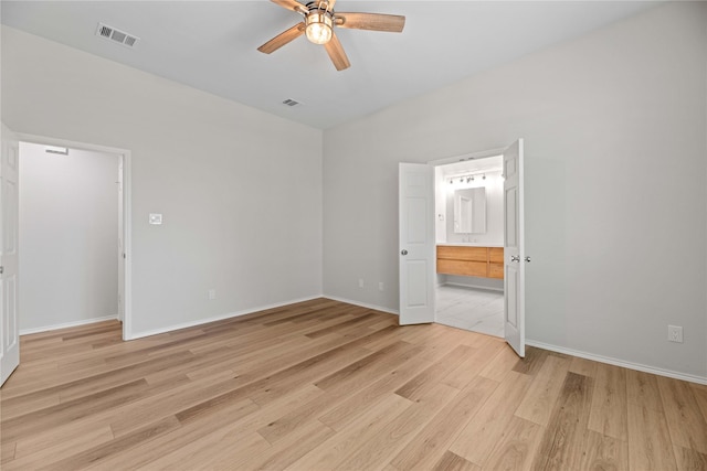 spare room featuring light wood-style flooring, a ceiling fan, visible vents, and baseboards