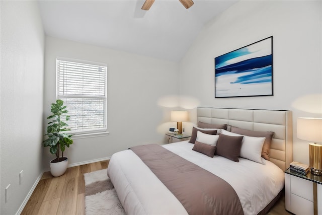 bedroom with baseboards, a ceiling fan, lofted ceiling, and wood finished floors