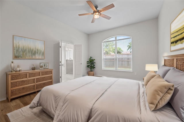 bedroom with ensuite bath, a ceiling fan, and wood finished floors