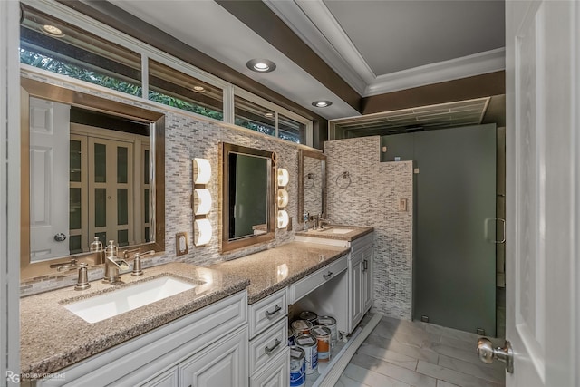 bathroom with double vanity, decorative backsplash, crown molding, and a sink