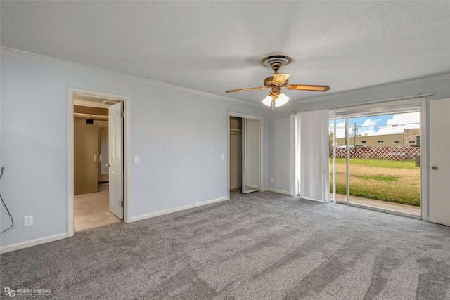 interior space featuring baseboards, a textured ceiling, crown molding, and carpet