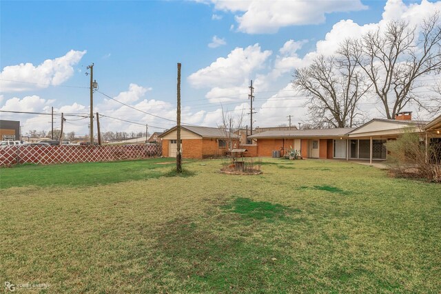 view of yard with an outbuilding, an attached garage, and fence