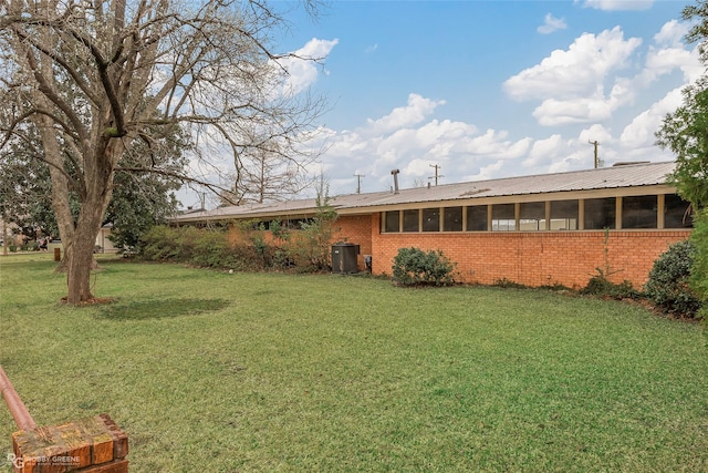 view of yard with central AC and a sunroom