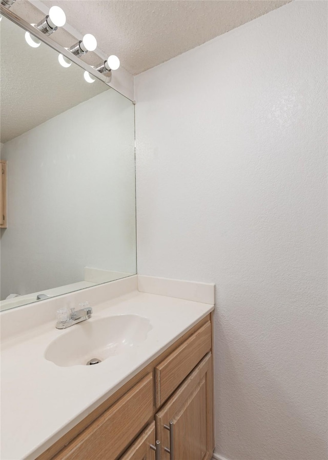 bathroom featuring a textured ceiling and vanity