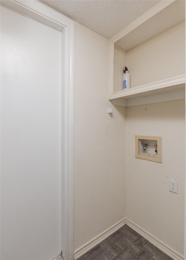 clothes washing area featuring baseboards, a textured ceiling, washer hookup, and laundry area