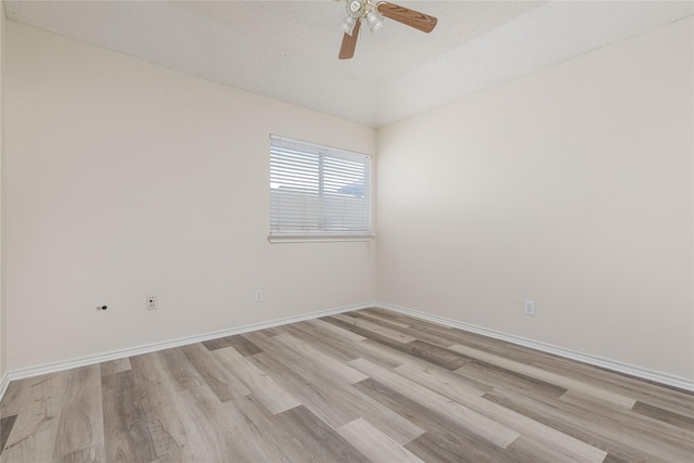 empty room with lofted ceiling, baseboards, light wood-type flooring, and ceiling fan