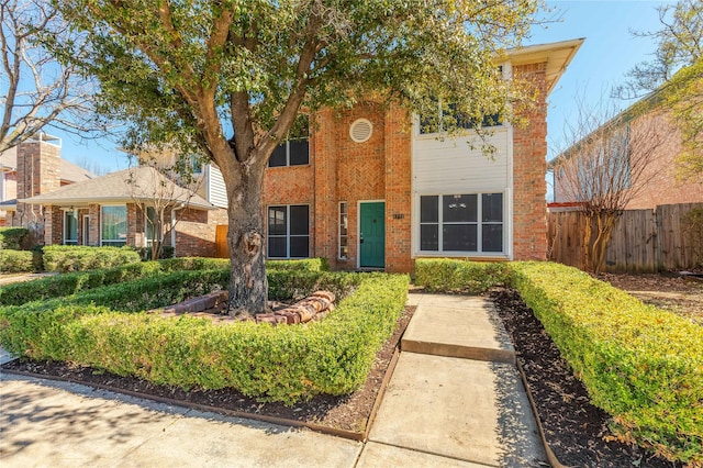 view of front of home with fence and brick siding