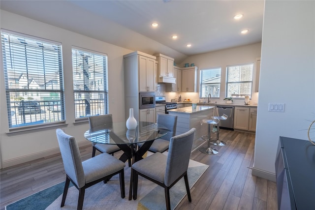 dining space featuring vaulted ceiling, recessed lighting, baseboards, and wood finished floors