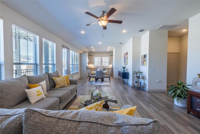 living area with visible vents, recessed lighting, baseboards, and wood finished floors