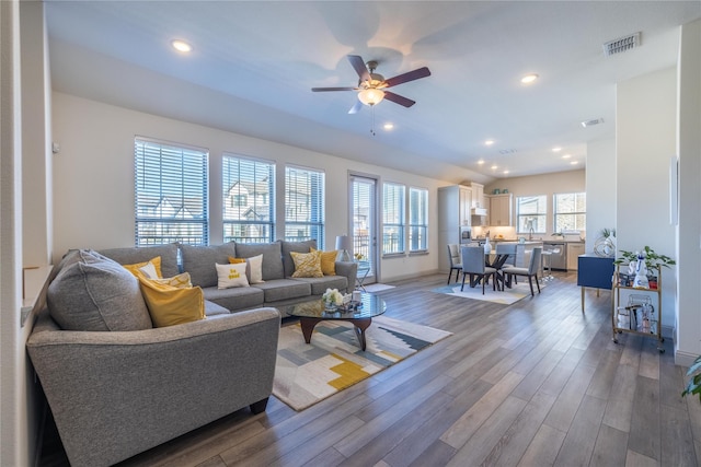 living room with wood finished floors, visible vents, recessed lighting, ceiling fan, and vaulted ceiling