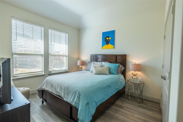 bedroom featuring baseboards and wood finished floors