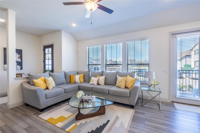 living room featuring a wealth of natural light, a ceiling fan, and light wood-style floors