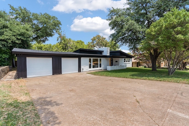 view of front of home featuring a garage, board and batten siding, concrete driveway, and a front yard