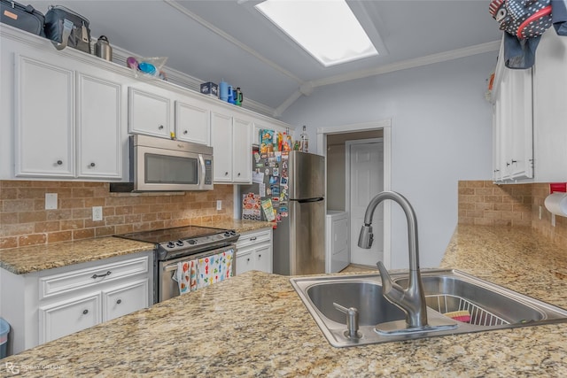 kitchen with ornamental molding, a sink, white cabinets, appliances with stainless steel finishes, and tasteful backsplash