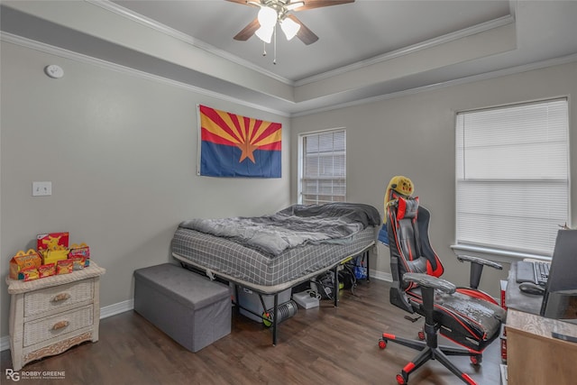 bedroom featuring a ceiling fan, wood finished floors, baseboards, crown molding, and a raised ceiling