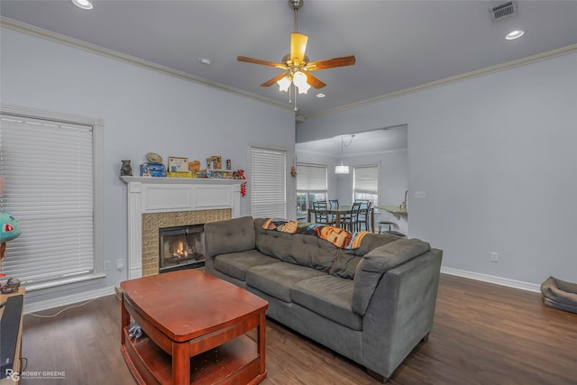 living room featuring visible vents, wood finished floors, crown molding, baseboards, and ceiling fan