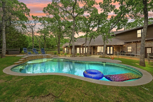 pool with a lawn and a patio area