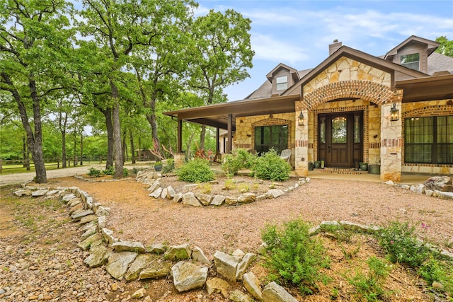 view of front of house with covered porch and stone siding