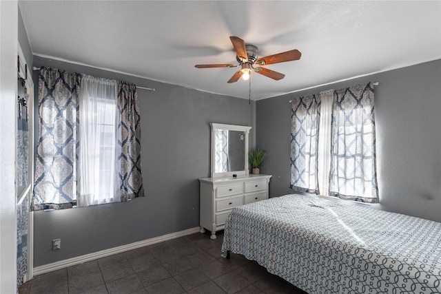 1306 N Floyd Rd, Richardson, TX 75080 - bedroom featuring dark tile patterned floors, a ceiling fan, and baseboards