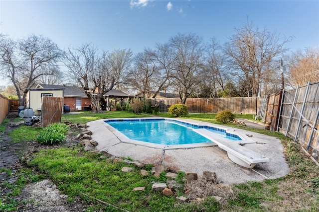 1306 N Floyd Rd, Richardson, TX 75080 - view of swimming pool featuring a fenced in pool, a fenced backyard, a yard, an outbuilding, and a diving board