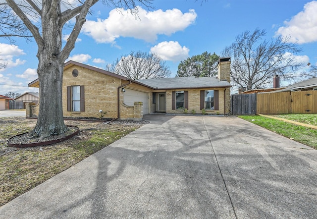 view of front facade featuring a garage, fence, brick siding, and driveway