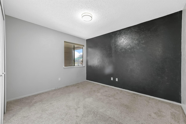 carpeted spare room featuring a textured ceiling